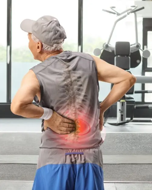 Older man experiences back pain in the gym